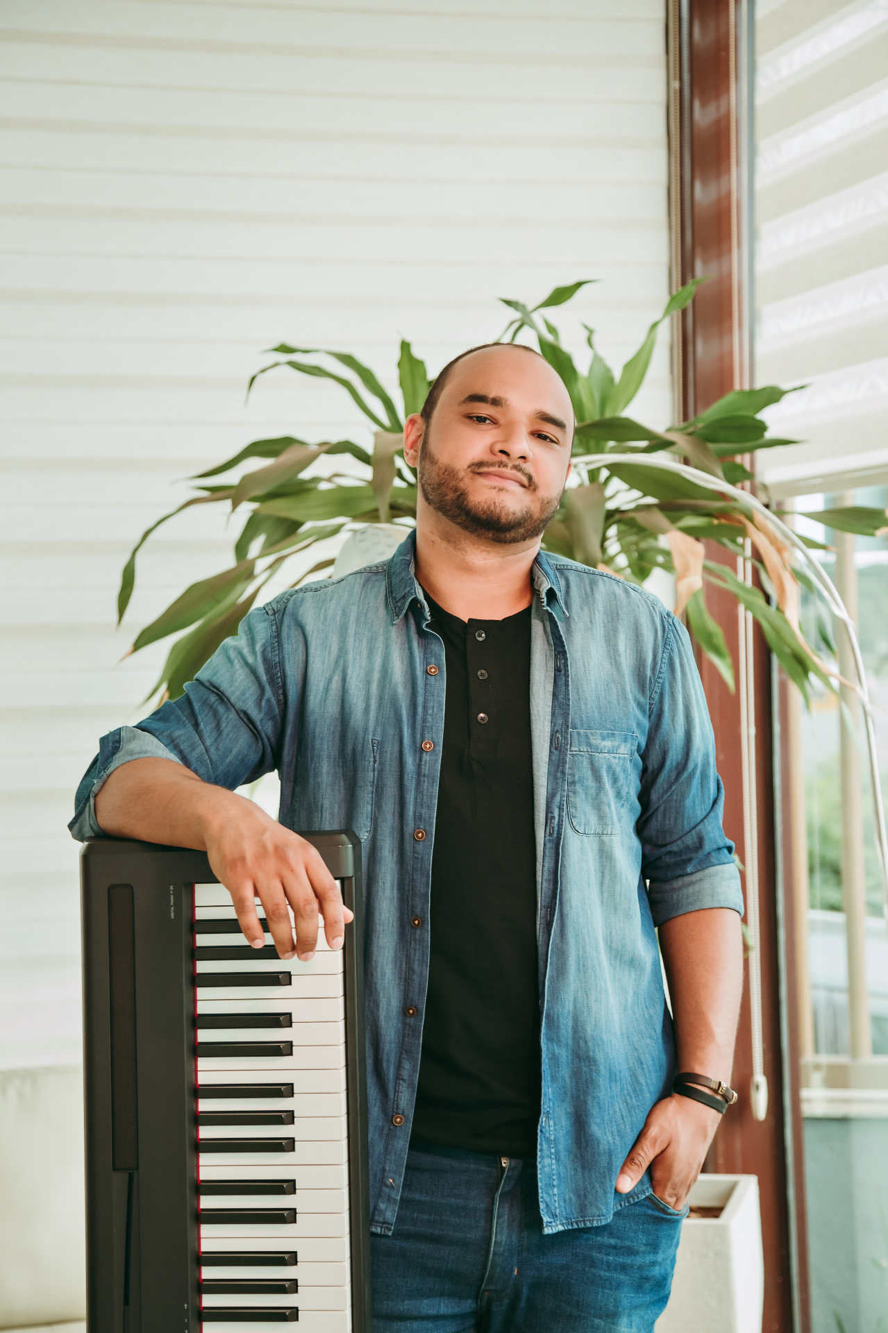 Spencer Pablo, professor de teclado, ao lado de um teclado musical